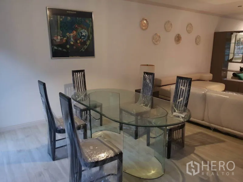 ทาวน์เฮาส์ ให้เช่าในKhlong Toei, Bangkok - พื้นที่ทานอาหาร โต๊ะกระจกทรงรี เก้าอี้หกตัว และงานศิลป์บนผนัง