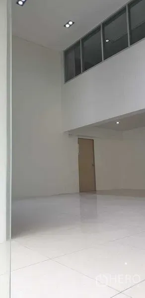 零售空间 出租在Chatuchak, Bangkok - 高挑白色展厅，带夹层窗与实心门。