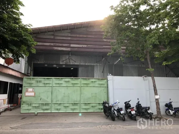 货栈 出租在Lak Si, Bangkok - 曼谷Lak Si区钢结构仓库外观，配大号绿色推拉门及临街出入口。