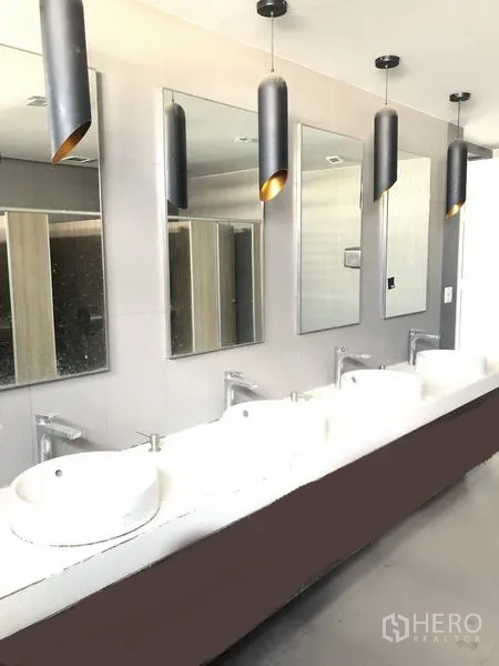 办公空间 出租在Suan Luang, Bangkok - 商业楼层卫生间，多个台上盆、镜面与吊灯，设计现代。