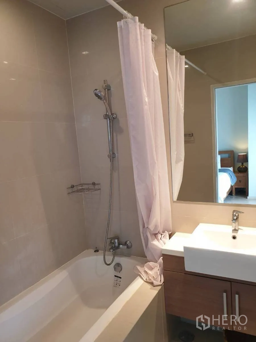 คอนโด ให้เช่าหรือขายในBangkok - ห้องน้ำพร้อมอ่างอาบน้ำ ฝักบัวเหนืออ่าง กระจกบานใหญ่ และอ่างล้างหน้า