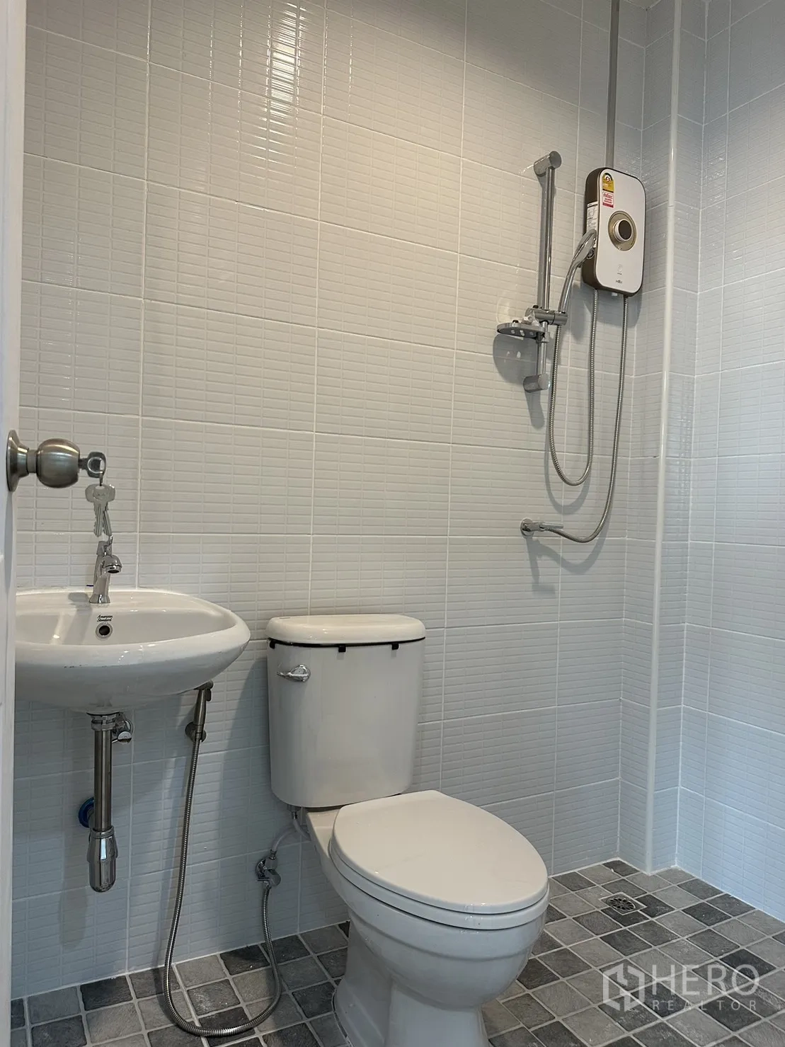 Warehouse for rent or sale - Clean bathroom with toilet, basin and electric shower heater.