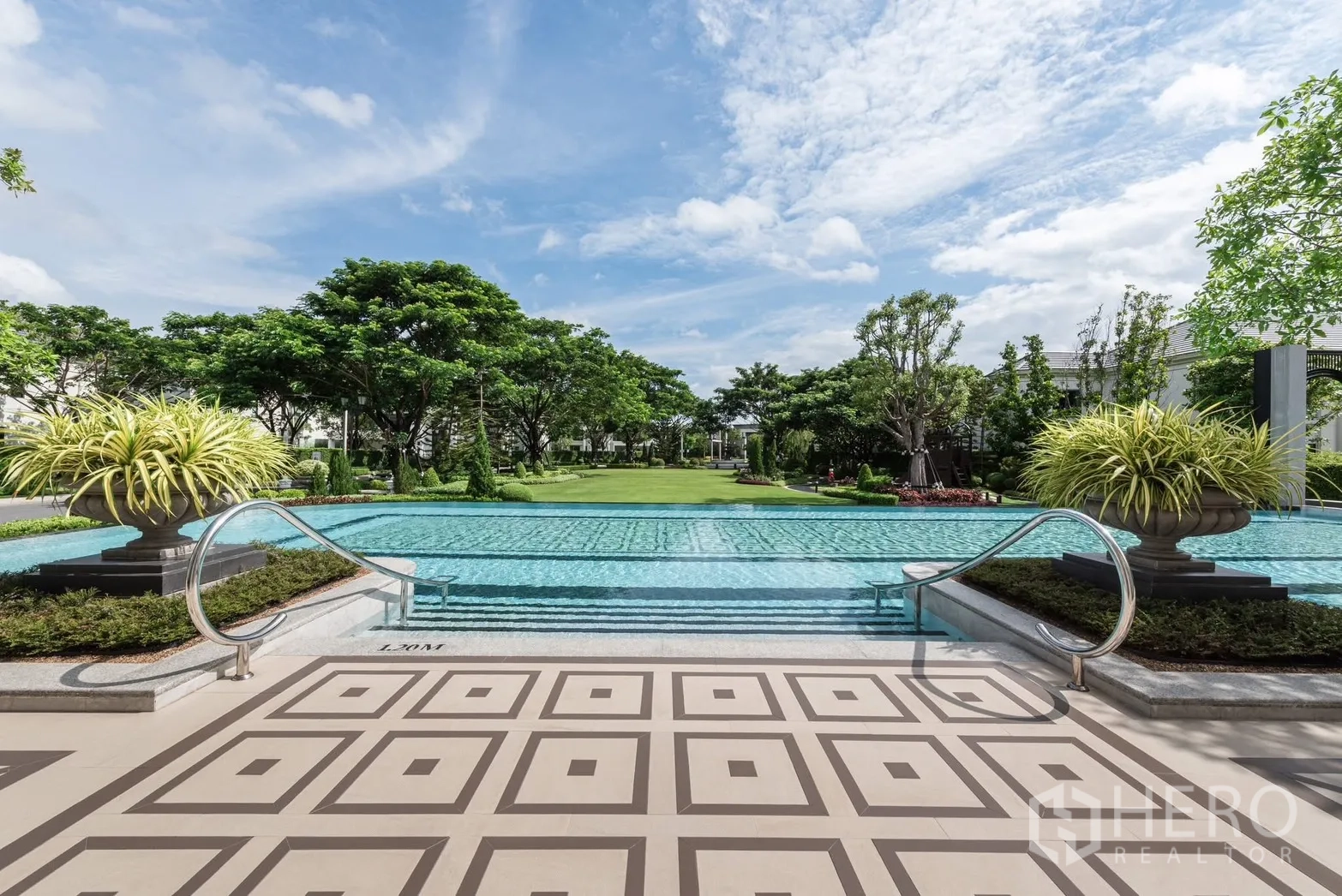 Detached House for rent or sale in Bang Phli, Samut Prakan - Grand pool with steps leading to a manicured lawn and tree-lined grounds.