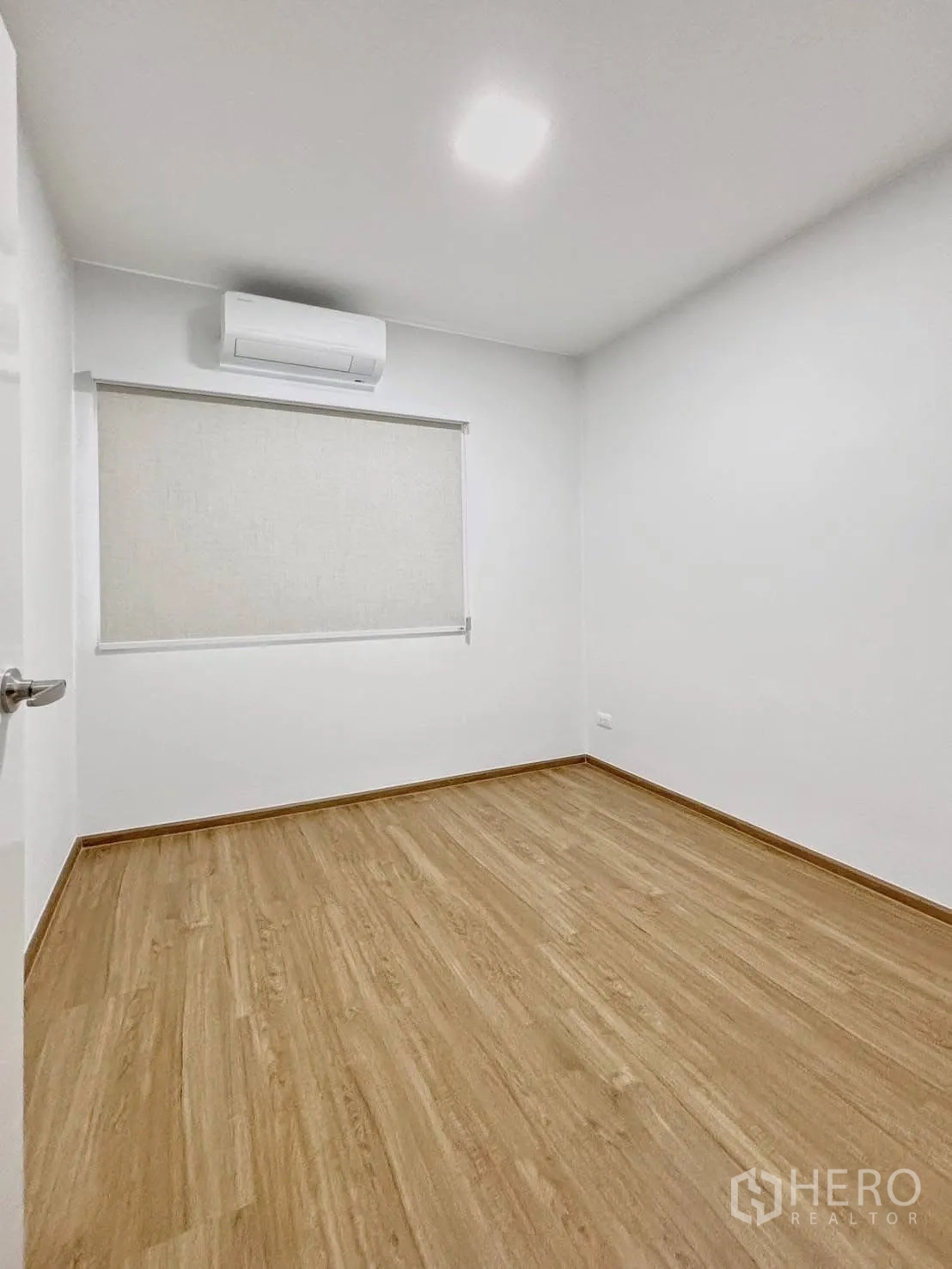 ทาวน์เฮาส์ for rent in Bang Phli, Samut Prakan - ห้องนอนโล่งปูพื้นลายไม้ มีม่านม้วนและเครื่องปรับอากาศ.