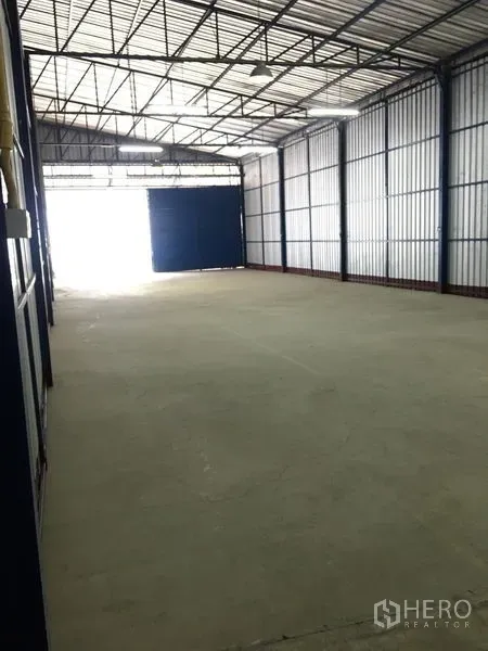 คลังสินค้า ให้เช่าในBang Kapi, Bangkok - มุมมองยาวของโกดัง พื้นคอนกรีตเรียบ เพดานสูง และประตูทางเข้าขนาดใหญ่ ขนย้ายได้สะดวก