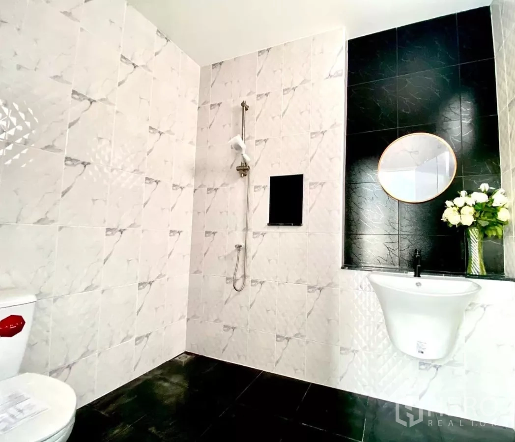 工厂 出租或出售在Bang Bua Thong, Nonthaburi - 全瓷砖卫浴，配淋浴、坐便与圆镜洗手台。