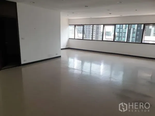 Office Space for rent in Khlong Toei, Bangkok - Spacious open-plan office with glossy flooring, long window line, white walls and downlights with city views.