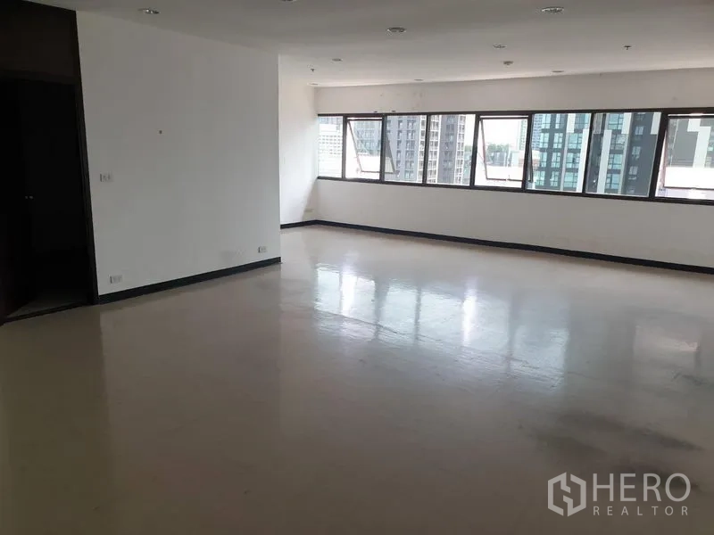 Office Space for rent in Khlong Toei, Bangkok - Spacious open-plan office with glossy flooring, long window line, white walls and downlights with city views.
