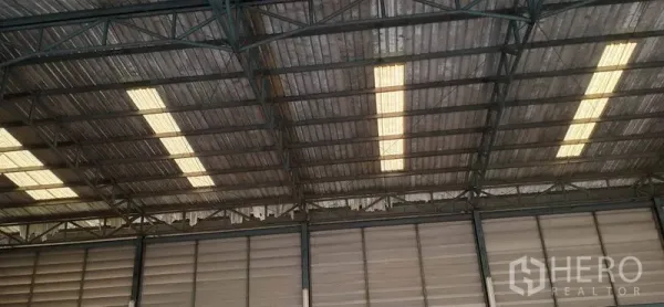 货栈 出租在Khlong Luang, Pathum Thani - 仓库内部钢桁架屋顶与采光板，自然采光充足。