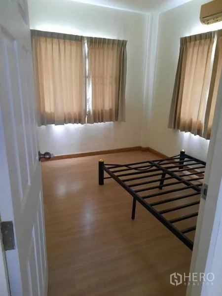 Home Office for rent in Watthana, Bangkok - Compact bedroom with metal bed frame and natural light from windows.