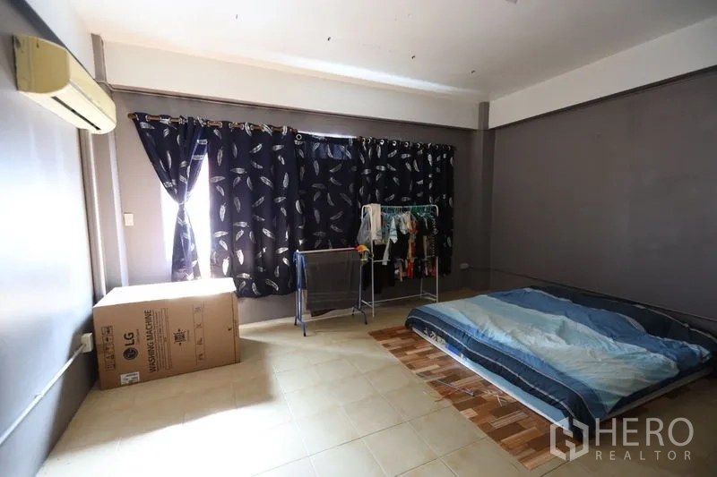 店屋 出租或出售在Watthana, Bangkok - 空调卧室，地铺床与深色窗帘及大纸箱