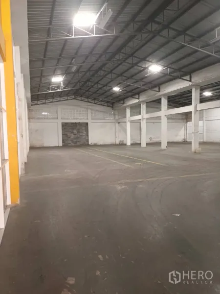 Warehouse for rent in Bang Phli, Samut Prakan - Warehouse space showing steel truss roof, bright lighting and broad clear-span lanes.