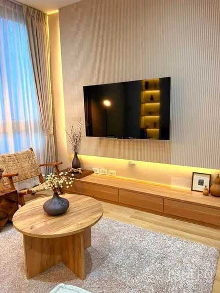 คอนโด ให้เช่าในRatchathewi, Bangkok - ห้องนั่งเล่นโทนอุ่น ทีวี คอนโซลไม้ โต๊ะกลางกลม และไฟบรรยากาศ
