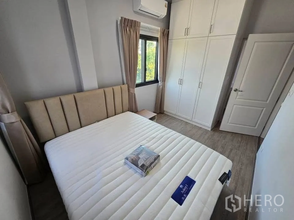 Semi-detached House for rent in Bang Phli, Samut Prakan - Cozy bedroom with window, built-in white wardrobe, bedside table, and air conditioner.