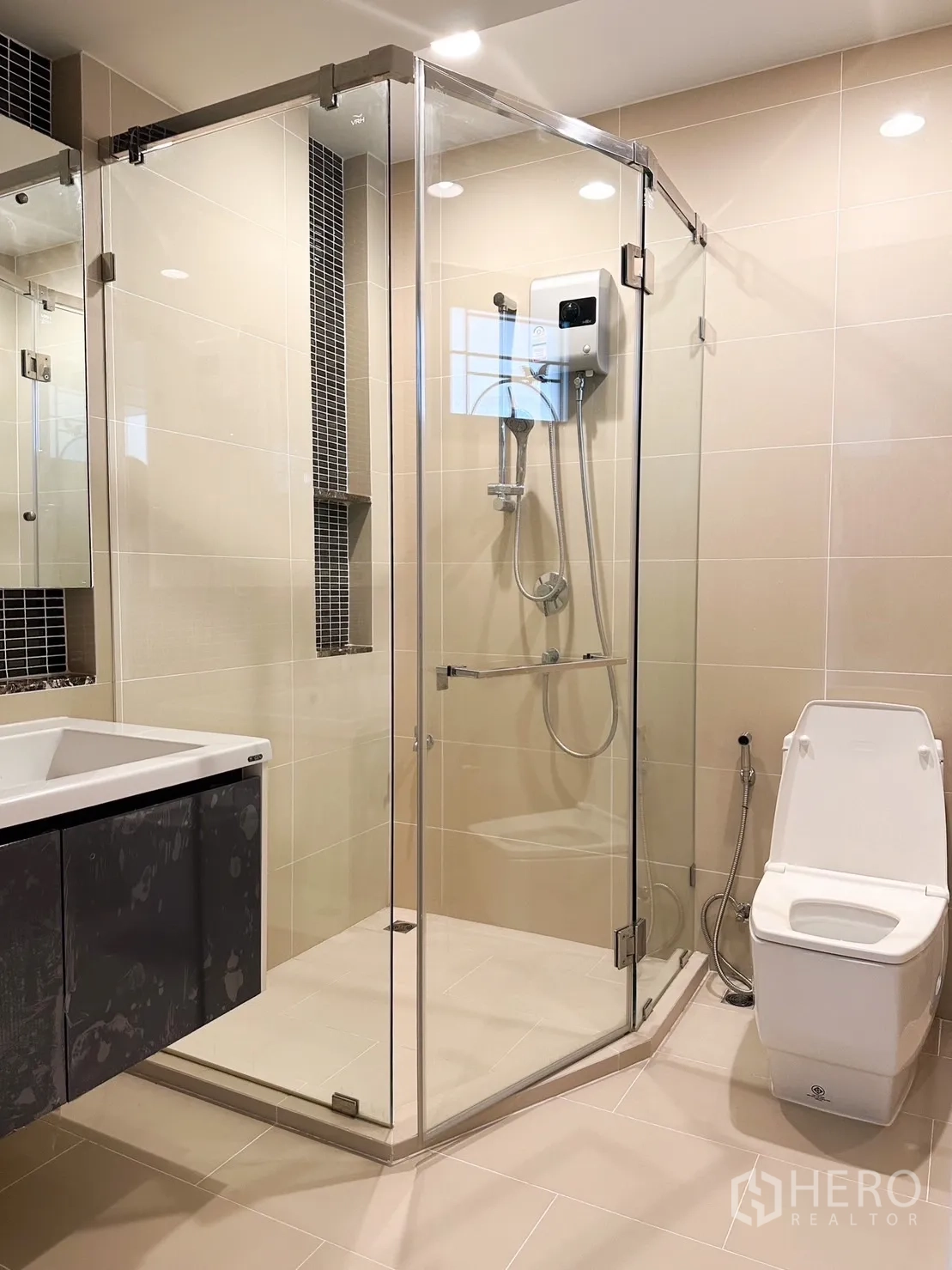 Detached House for rent or sale in Bang Kapi, Bangkok - Contemporary bathroom with frameless glass shower and beige tiles.