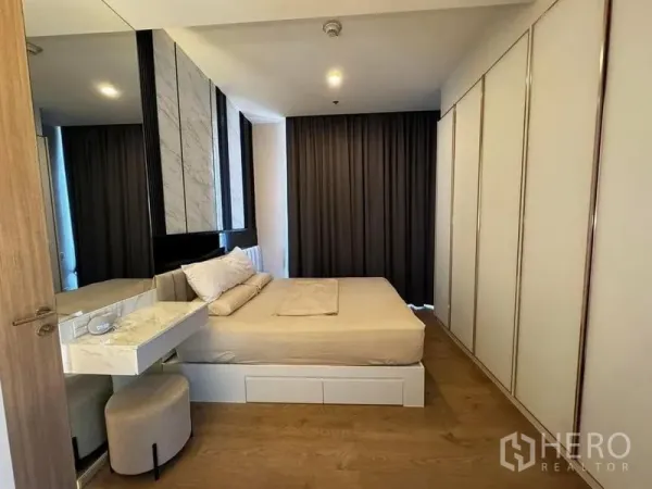 Condominium for rent in Watthana, Bangkok - Cozy bedroom with built-in wardrobes, marble headboard and blackout curtains.