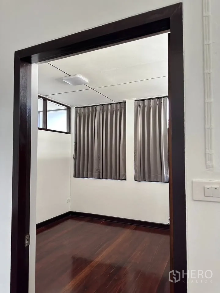 独栋房屋 for rent in Phra Khanong, Bangkok - 紧凑房间，深色木地板与灰色窗帘。