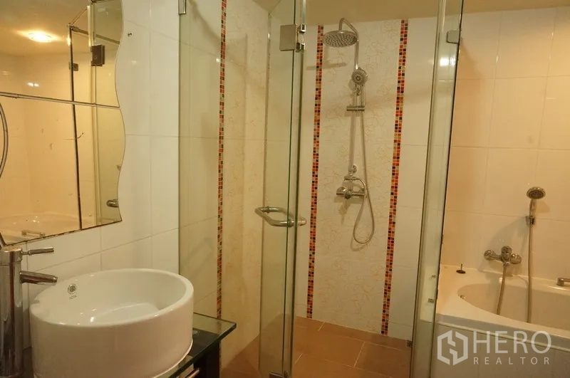 Condominium for rent in Watthana, Bangkok - Bathroom with glass shower enclosure, rain shower and built-in bathtub.