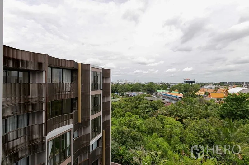 คอนโด ขายในWatthana, Bangkok - อาคารคอนโดโลว์ไรส์สมัยใหม่พร้อมระเบียงโค้ง มองเห็นวิวสวนเขียวและสกายไลน์ในเขตวัฒนา กรุงเทพฯ