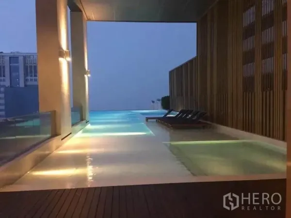 公寓 出租在Watthana, Bangkok - 屋顶无边泳池，配躺椅与天际线景色。