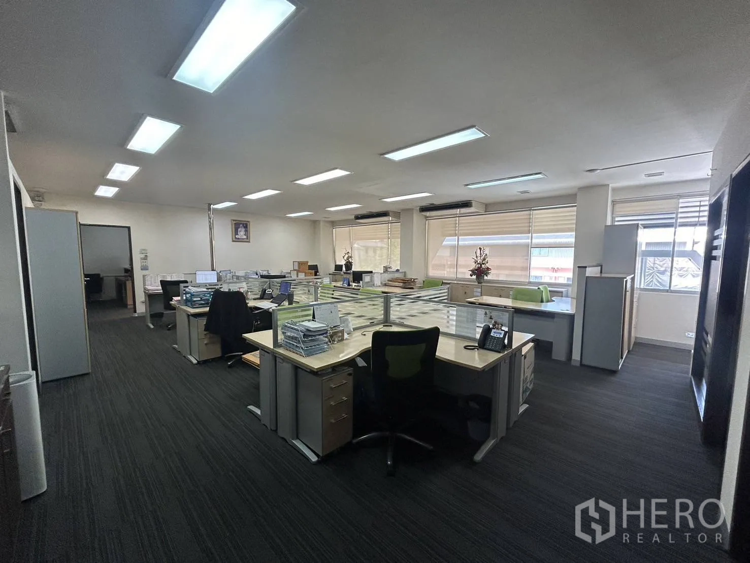 สำนักงาน ให้เช่า - พื้นที่ทำงานแบบเปิด โต๊ะทำงานหลายชุด พื้นพรมและหน้าต่างบานใหญ่รับแสงธรรมชาติ