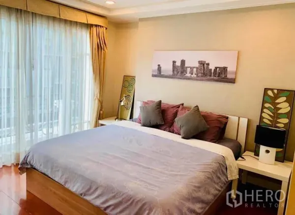 Condominium for rent in Khlong Toei, Bangkok - Master bedroom with king bed, floor-to-ceiling curtains and soft balcony light.