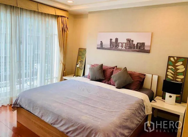 Condominium for rent in Khlong Toei, Bangkok - Master bedroom with king bed, floor-to-ceiling curtains and soft balcony light.