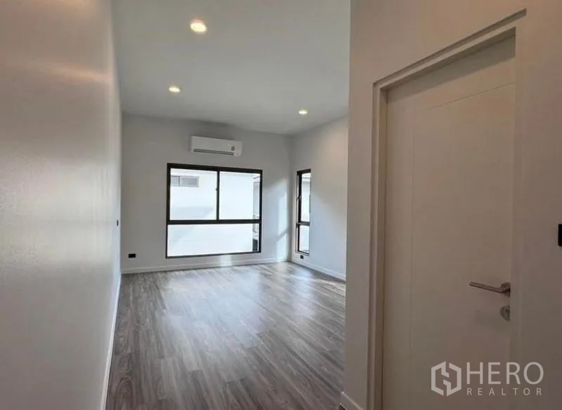 Detached House for rent in Bang Kapi, Bangkok - Side garden with manicured lawn, shrubs and privacy fencing.