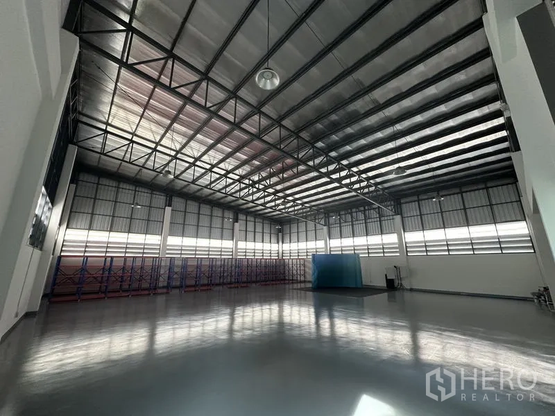 Factory for sale in Lam Luk Ka, Pathum Thani - Warehouse interior with skylights, racking and polished flooring.