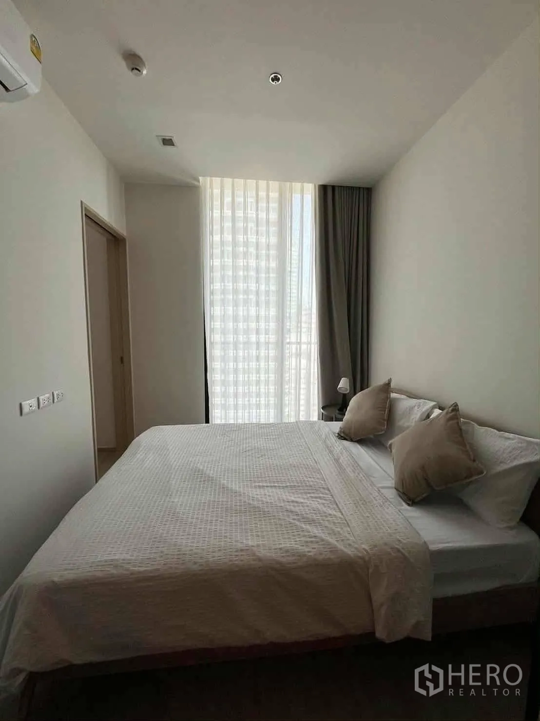 公寓 for rent in Watthana, Bangkok - 明亮卧室，配大床、靠枕与高挑纱帘窗户。
