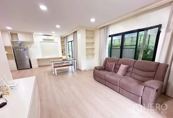 บ้าน ขายในLam Luk Ka, Pathum Thani - โซนนั่งเล่นและทานข้าวแบบเปิดโล่ง โซฟาสีน้ำตาล ตู้บิวท์อิน และหน้าต่างบานใหญ่ติดสวน