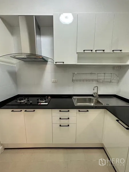 Townhouse for rent in Chom Thong, Bangkok - Modern kitchen close-up of two-burner gas cooktop, hood and sink.
