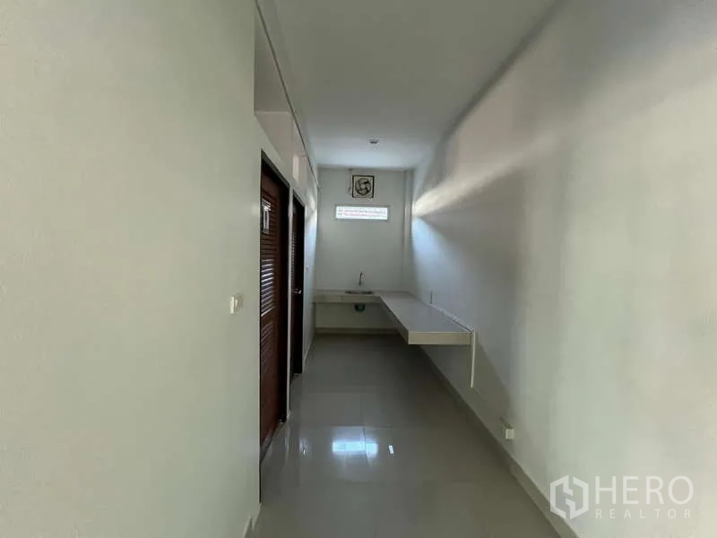 货栈 出租在Prawet, Bangkok - 办公区走廊，设洗手池与卫生间门。