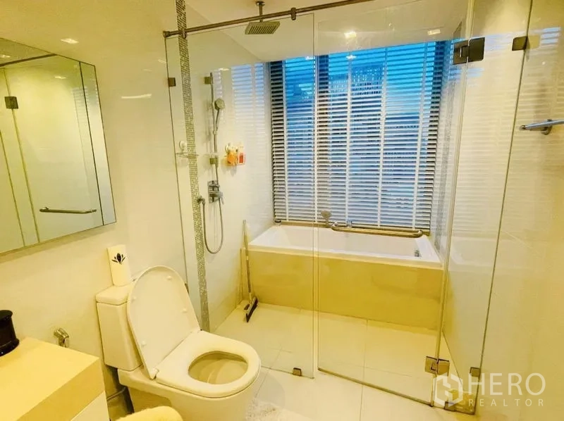 公寓 出租或出售在Sathon, Bangkok - 现代卫生间，玻璃淋浴间、浴缸与百叶窗。
