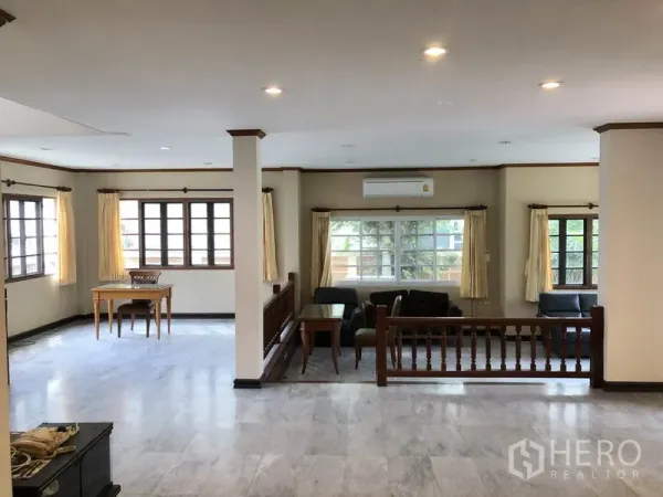 独立式住宅 出租 - 采光充足的错层客厅，多扇窗户、沙发与仿大理石地面。