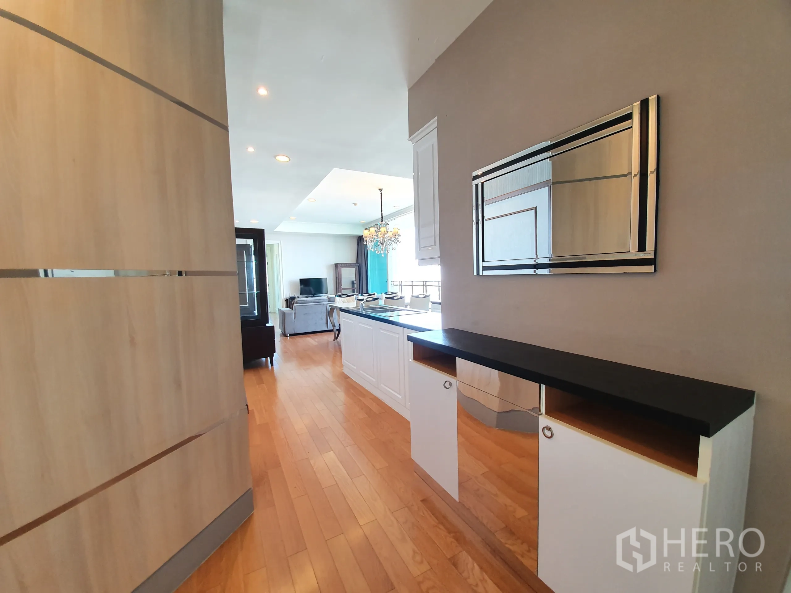 公寓 出租在Watthana, Bangkok - 入口走廊设玄关柜与镜子，通向明亮的开放式起居区。