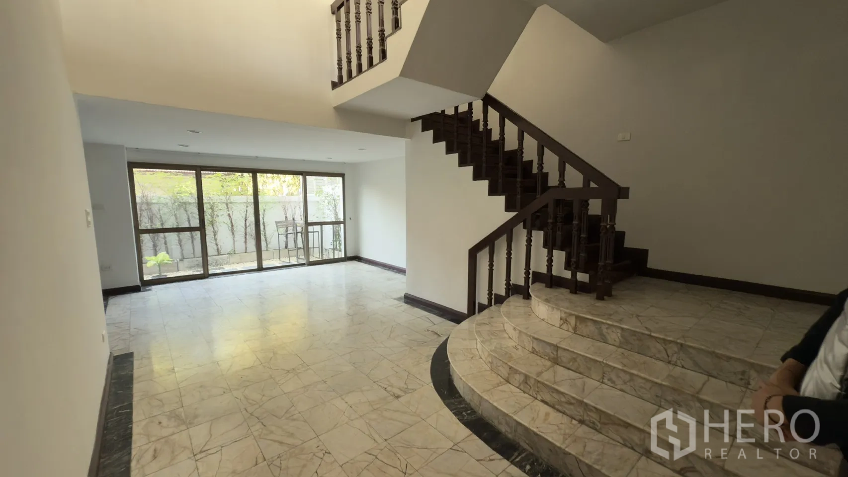 ทาวน์เฮาส์ for rent in Watthana, Bangkok - ห้องโถงเปิดโล่งเห็นขั้นบันไดหินอ่อนโค้งสู่บันไดและประตูออกลาน