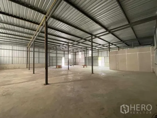 Warehouse for rent in Nong Khaem, Bangkok - Open warehouse interior with steel columns, high metal roof and concrete floor.