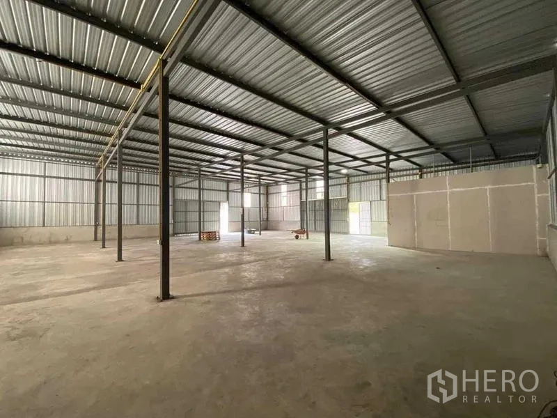 Warehouse for rent in Nong Khaem, Bangkok - Open warehouse interior with steel columns, high metal roof and concrete floor.