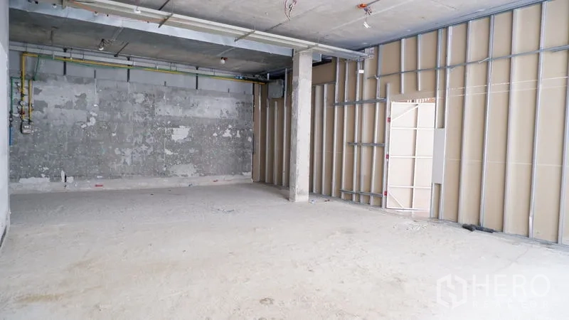 零售空间 出租在Watthana, Bangkok - 开放店铺区域，一侧金属龙骨，空间布局灵活。