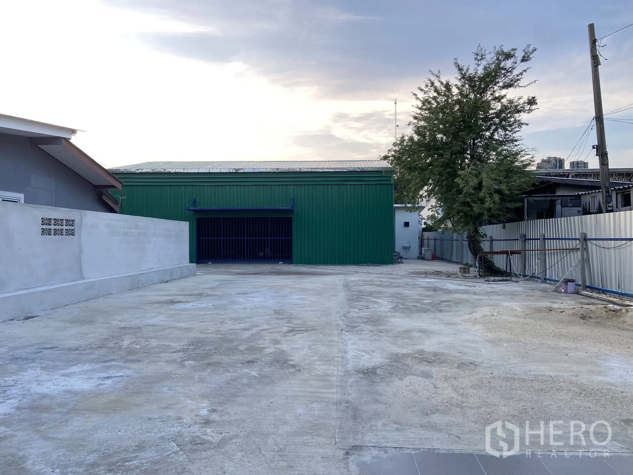 Warehouse for rent in Bang Na, Bangkok - Long driveway leading to a warehouse building with a wide entrance and open yard.