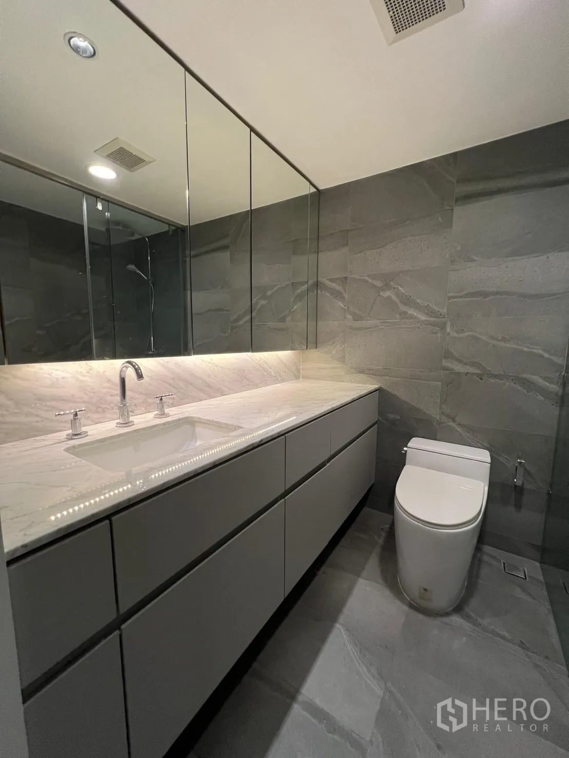 คอนโด ให้เช่าหรือขายในSathon, Bangkok - ห้องน้ำแขก เคาน์เตอร์หินอ่อน ตู้กระจก และผนังหินโทนเทา