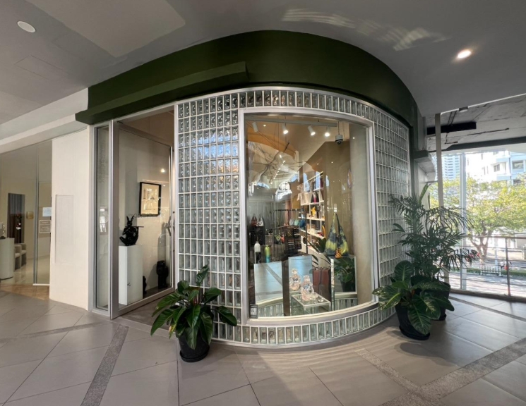 零售空间 出租在Khlong Toei, Bangkok - 素坤逸零售铺位的弧形玻璃砖立面，配大展示窗与盆栽绿植