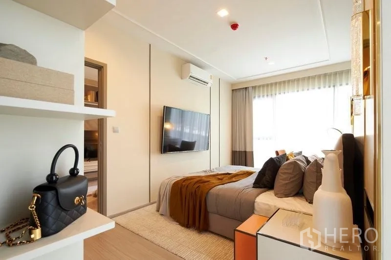 คอนโด ขายในRatchathewi, Bangkok - ห้องนอนหลักพร้อมทีวีติดผนัง หน้าต่างบานใหญ่ โทนอบอุ่น