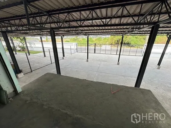 Office Space for rent in Bang Sao Thong, Samut Prakan - Covered loading bay and wide concrete forecourt behind a secure metal fence.