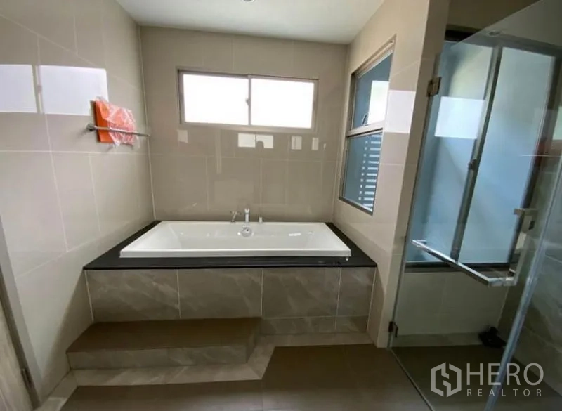 บ้าน ให้เช่า - ห้องน้ำมีอ่างอาบน้ำแบบบิวท์อินบนแท่นยกระดับ และตู้อาบน้ำกระจกแยกส่วน