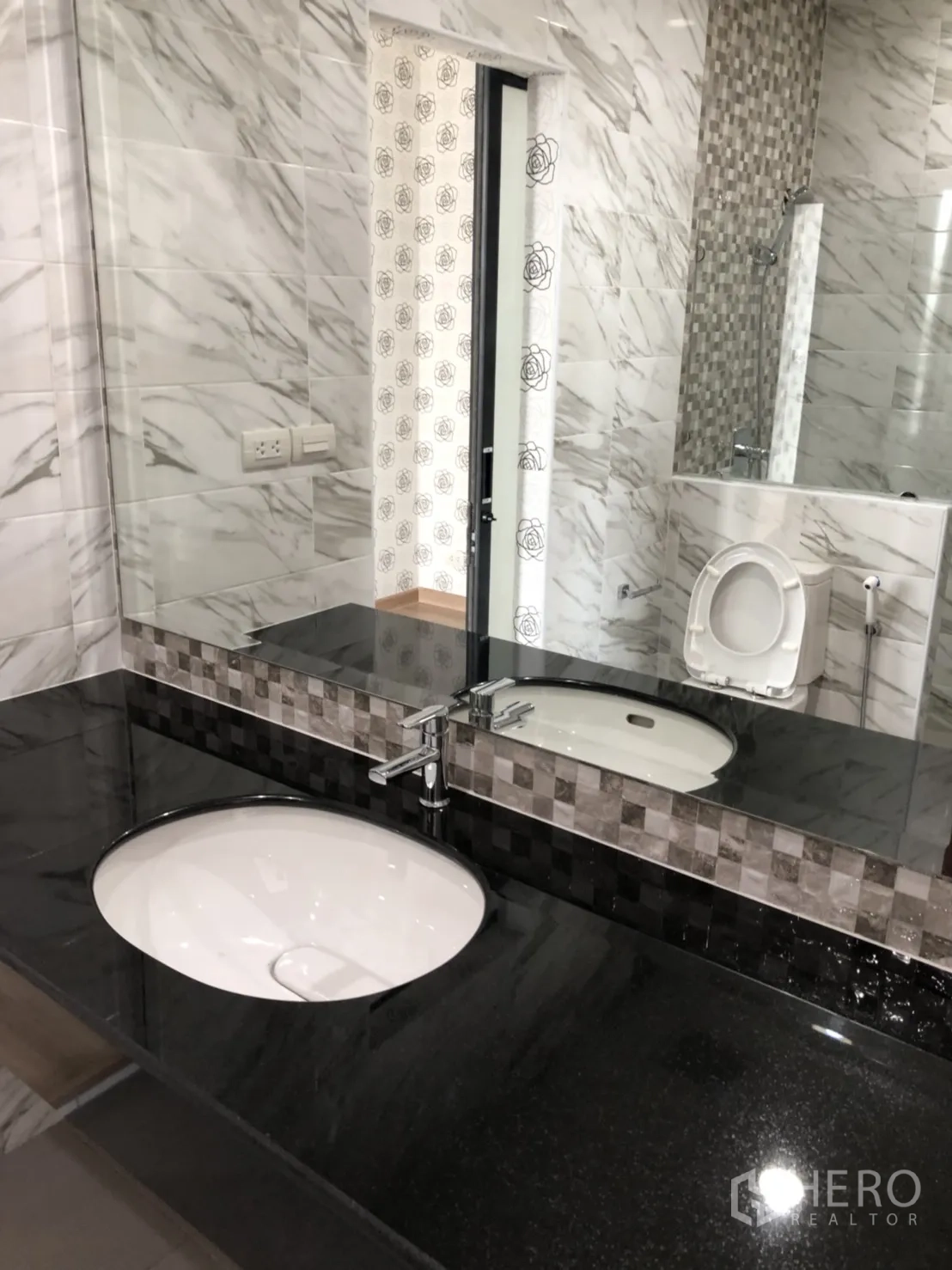 Townhouse for rent in Din Daeng, Bangkok - Modern bathroom with black granite vanity, large mirror, and marble-effect wall tiles.