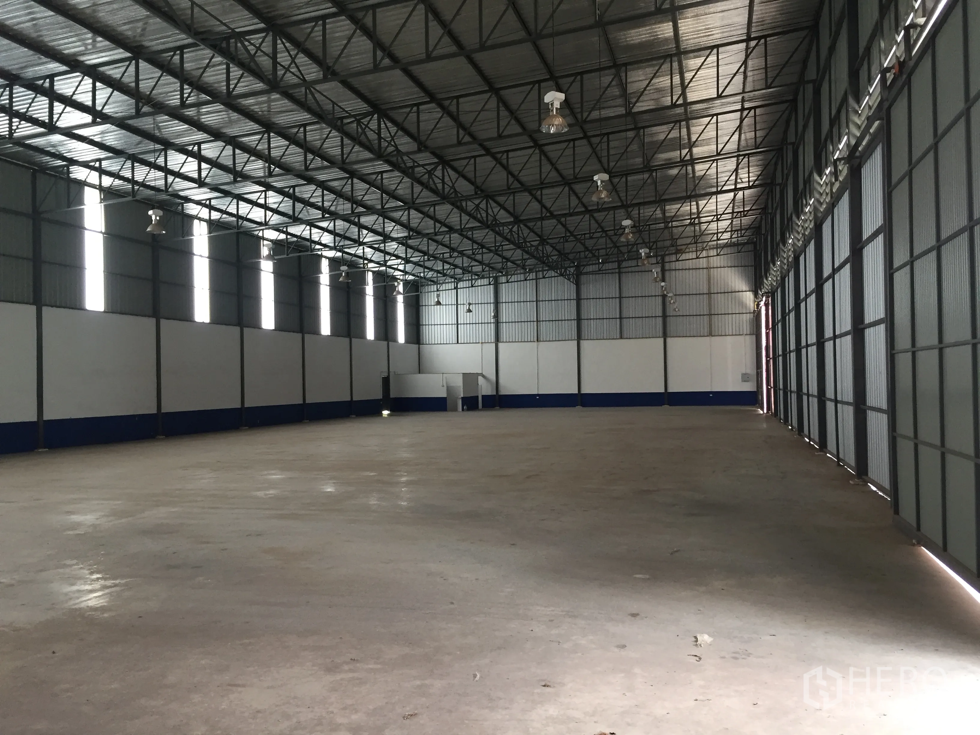 货栈 出租在Pathum Thani - 宽大的仓库大厅，排布高天棚灯与采光带，地面平整。