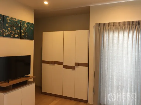 คอนโด ให้เช่าในPhaya Thai, Bangkok - พื้นที่นั่งเล่นคอนโดสไตล์โมเดิร์น มีชั้นวางทีวี ตู้เสื้อผ้าสีขาว และผ้าม่านยาว