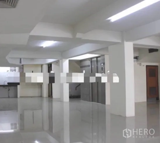 อาคารพาณิชย์ ให้เช่าในKhlong Toei, Bangkok - พื้นที่ชั้นล่างแบบโอเพนสเปซ พื้นกระเบื้องเงา เสากลางอาคาร และโถงลิฟต์